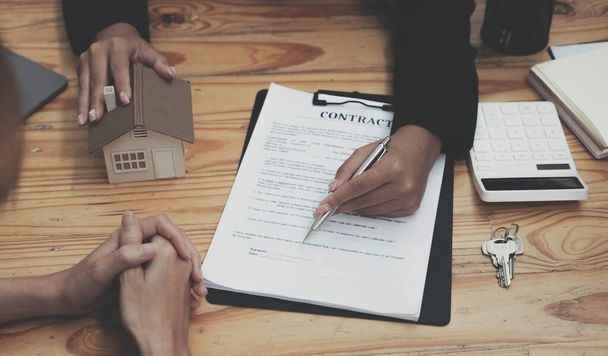 不動産業者は、住宅購入契約の条件について話し、顧客に契約を合法的にするために文書に署名するように依頼しました、住宅販売と住宅保険の概念 - 写真・画像