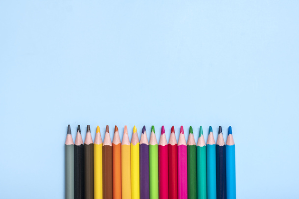 set van gekleurde potloden geïsoleerd op blauwe achtergrond Bovenaanzicht Flat lay Onderwijs, ambacht concept Mock up. - Foto, afbeelding