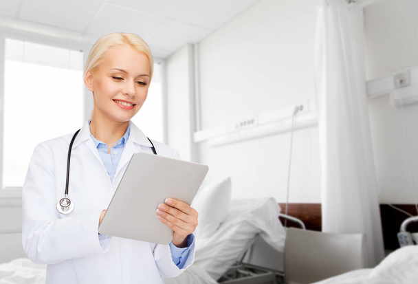 healthcare, technology and medicine concept - smiling female doctor with tablet pc computer over hospital ward background - Фото, зображення