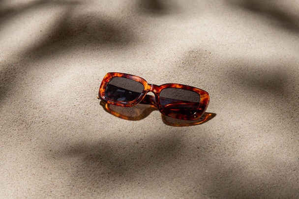 akcesoria letnie i koncepcja okularów - okulary przeciwsłoneczne żółwia na piasku plażowym - Zdjęcie, obraz
