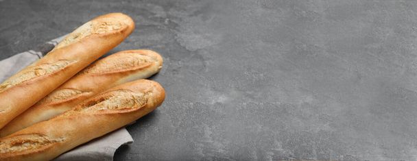 Tasty baguettes on grey table, space for text. Banner design - Zdjęcie, obraz