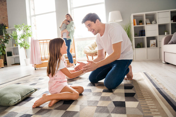 Photo of funny sweet husband wife little children father playing patty cake game smiling indoors room home house. - Foto, Imagem