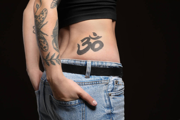 Woman with tattoos on body against black background, closeup - Фото, изображение