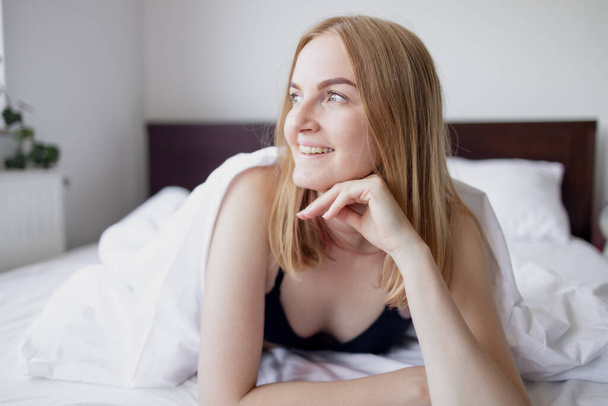 Seksikäs alaston nuori 30s blondi nainen makaa sängyssä makuuhuoneessa - Valokuva, kuva