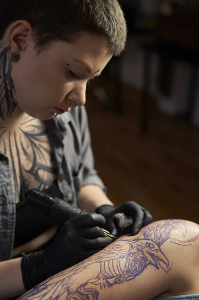 Primer plano del dibujo del artista del tatuaje en el brazo del cliente - Foto, imagen