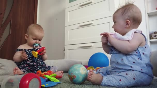 Bratrské dvojčata dívky sestry, hrát si s hračkami na podlaze doma - Záběry, video