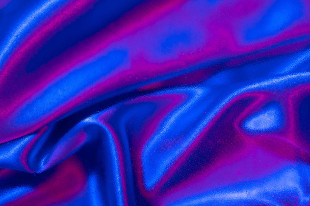 Textiles bajo vidrio con gotas de agua en luz de neón. Colores de moda y fondo brillante. - Foto, Imagen