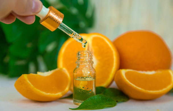 Ätherisches Orangenöl in einer kleinen Flasche. Selektiver Fokus. Natur. - Foto, Bild