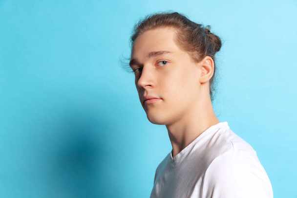 Closeup portrait of young man, student posing isolated on blue background. Emotional, young face. male half-length portrait. Human emotions, facial expression concept. Trendy colors - Foto, Bild