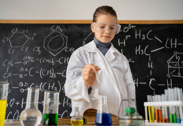 Okul laboratuarında kimyasal deneyler yapan kız öğrenci, okul çocukları için kimya sınıfında bilimsel deneyim, eğitim ve bilim konsepti - Fotoğraf, Görsel