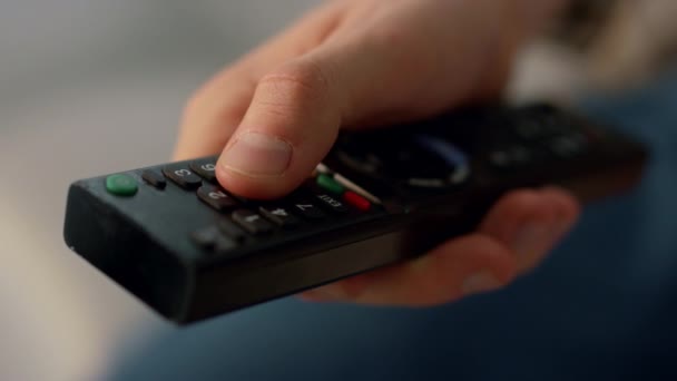 Fingers pushing remote control buttons closeup. Unknown man switching channels resting home. Unrecognized person watching television show relaxing home. Guy select TV set program on weekend evening. - Footage, Video