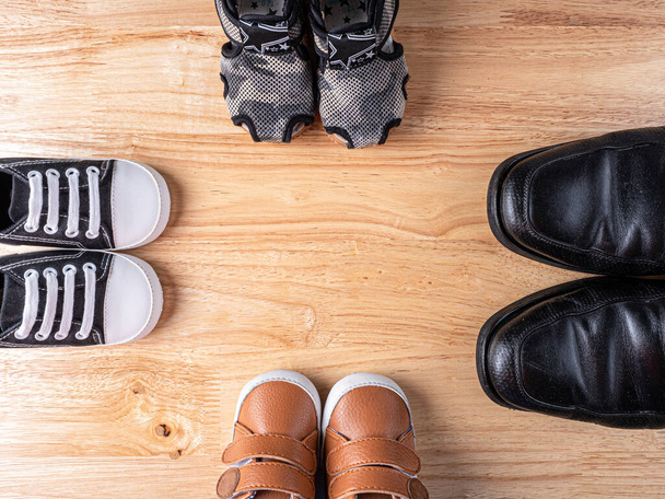 lovely baby shoes on wooden background with his father's boot, prepare for baby concept. - 写真・画像