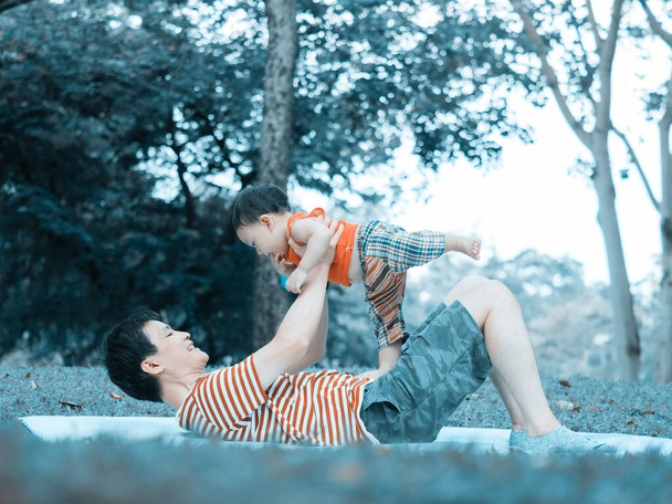 Close up shot of cute asian baby in lovely actions in the outdoor nature, health care and fatherhood concept. - 写真・画像