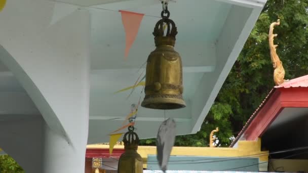 Campana de hierro de latón colgando en el techo del pabellón con el sonido de la brisa del viento en Wat Phra Kaew para los tailandeses y viajeros extranjeros visita de viaje y respeto rezar en San Buri en Chai Nat, Tailandia - Imágenes, Vídeo