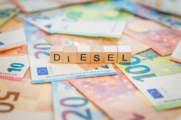 Η λέξη Diesel σε χαρτονομίσματα του ευρώ γραμμένη με ξύλινους κύβους - Φωτογραφία, εικόνα