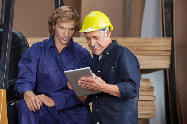 Carpenter Using Digital Tablet With Colleague - Photo, image
