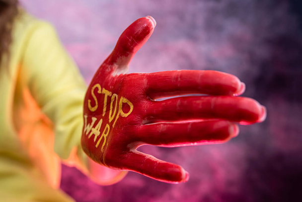 todo el mundo contra la guerra. Rusia terrorista internacional. parar la guerra la pintura roja a las manos femeninas  - Foto, imagen