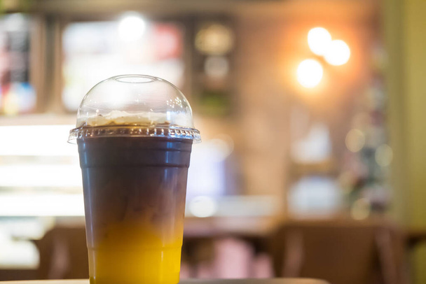 Склянка кави з льодом, змішаної з апельсиновим соком, два тони шару
 - Фото, зображення
