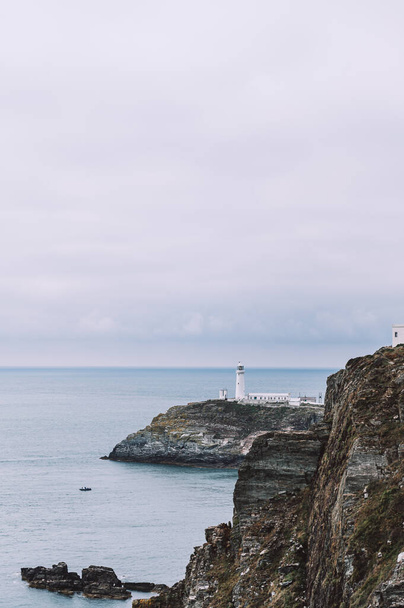 Faro de South Stack, Gales, Anglesey, Reino Unido. Está construido en la cima de una pequeña isla frente a la costa noroeste de la Isla Santa. Fue construido en 1809 para advertir a los barcos de las peligrosas rocas de abajo.. - Foto, Imagen