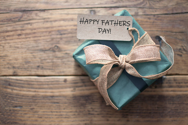 Fathers day greeting attached to gift box wrapped with a rustic ribbon bow - Zdjęcie, obraz