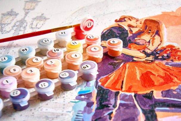 Ucrania - Mayo 2022: Pintura pintada a medias por números usando tarros de pintura acrílica y un pincel. Enfoque selectivo, desenfoque de luz, borro.Editorial - Foto, Imagen
