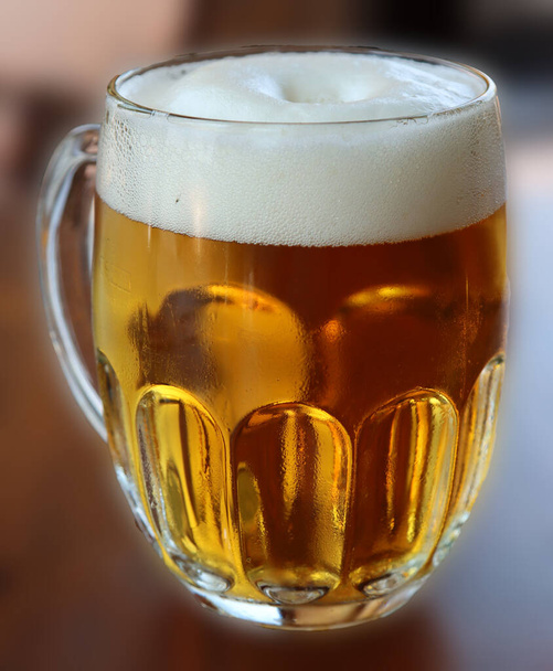 glass with handle full of light beer with foam - Foto, afbeelding
