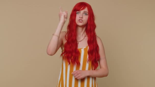 Tartışma. Hoşnutsuz kızıl saçlı kadın, kızarıklık ve hoşnutsuzlukla el kol hareketi yapıyor, başarısızlıktan dolayı azarlıyor, bunun neden olduğunu soruyor. Genç kızıl kız bej renkli stüdyo arka planında tek başına izole edilmiş. - Video, Çekim