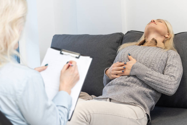 Psychologe tröstet eine depressive Frau während einer psychologischen Therapiesitzung im Büro, die Dame braucht professionelle Hilfe. - Foto, Bild