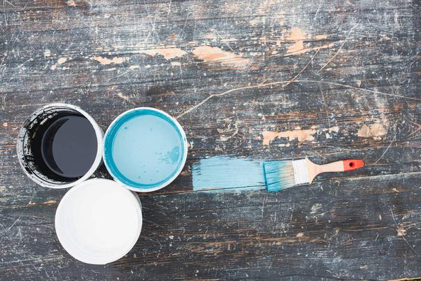 House renovation concept.Paint cans and brush on the old wooden background with copy space - Foto, Imagem