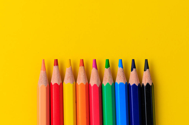 Színes ceruzák és sárga másolási hely a szöveghez vagy a betűkhöz. Kreatív háttér. - Fotó, kép
