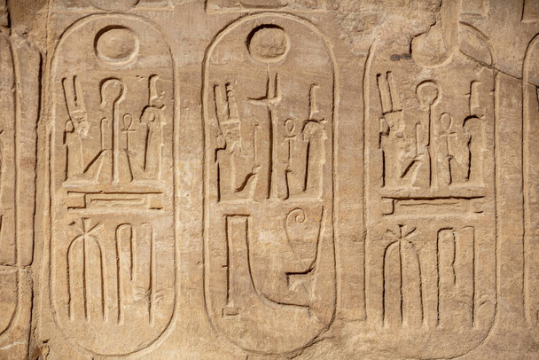 Different hieroglyphs on the walls and columns in the Karnak temple. Karnak temple is the largest complex in ancient Egypt. - Photo, Image
