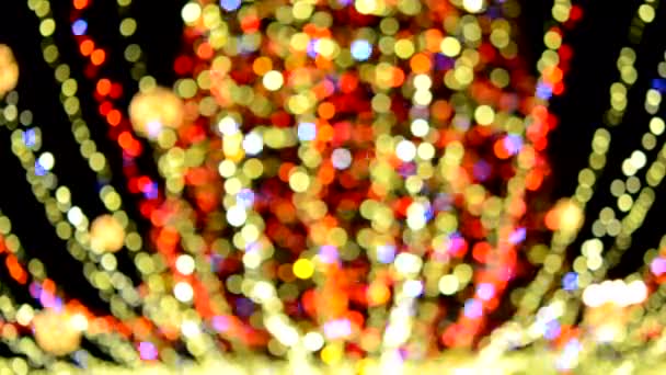 Duża choinka noworoczna ozdobiona świecącymi wieńcami wielobarwnymi i oświetleniem w nocy. Choinka z migającymi światełkami. Zamazane tło. Nowy Rok i święta Bożego Narodzenia - Materiał filmowy, wideo