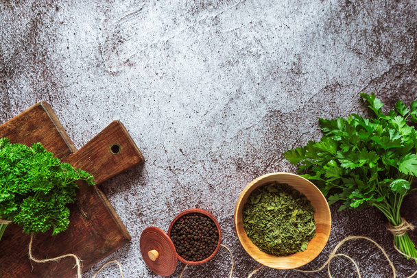 fresh fragrant farm green and dried parsley, pepper peas on a gray concrete background. Place for text, top view - Foto, Bild