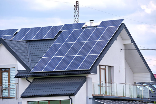 Casa residenziale con tetto coperto con pannelli fotovoltaici solari per la produzione di energia elettrica ecologica pulita in zona rurale suburbana. Concetto di casa autonoma. - Foto, immagini