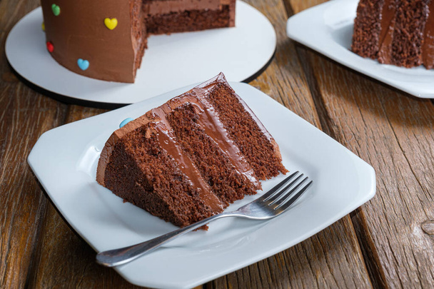 Φέτα κέικ σοκολάτας με γέμιση και ημι-γλυκό γλάσο σοκολάτας γκανάς. - Φωτογραφία, εικόνα