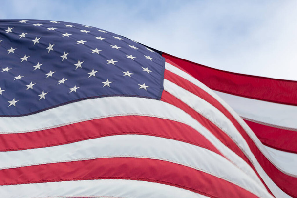 Σημαία Ηνωμένων Πολιτειών κινείται με μπλε ουρανό στο παρασκήνιο - Φωτογραφία, εικόνα