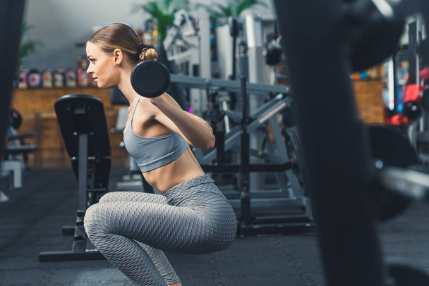 Une photo d'une belle femme faisant des squats de poids à la salle de gym, horizontale. Photo de haute qualité - Photo, image