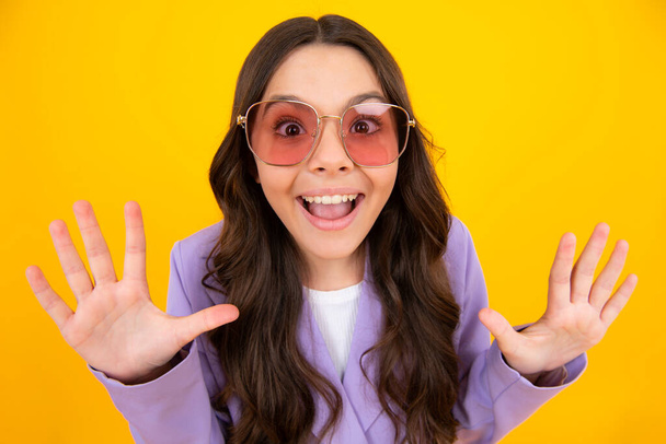 Amazed teen girl. Shocked teenager child with amazed look on yellow background, amazement. Excited expression, cheerful and glad - Фото, изображение