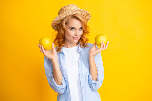 Молода жінка тримає яблука, дивлячись на камеру з сексуальним виразом, веселим і чуттєвим обличчям
 - Фото, зображення