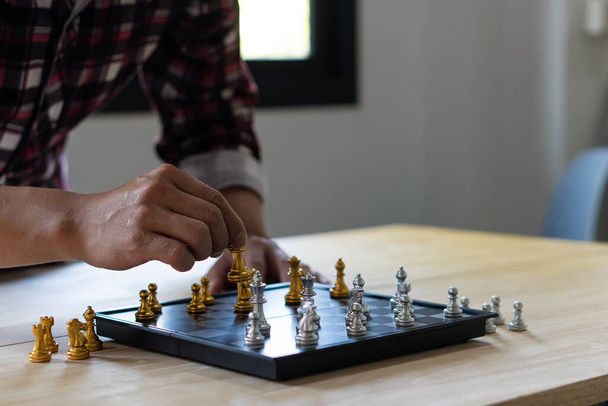 Zbliżenie rąk pewnego siebie człowieka grającego w szachy do analizy rozwoju nowych strategii, liderów i pomysłów na pracę zespołową dla sukcesu biznesowego. - Zdjęcie, obraz