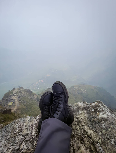 patikoija jalka lepää vuoren huipulla tasaisesta kulmasta aamulla - Valokuva, kuva