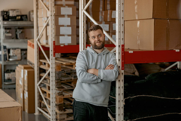 Portrait of handsome business owner standing on the warehouse with coffee machines on background - Zdjęcie, obraz