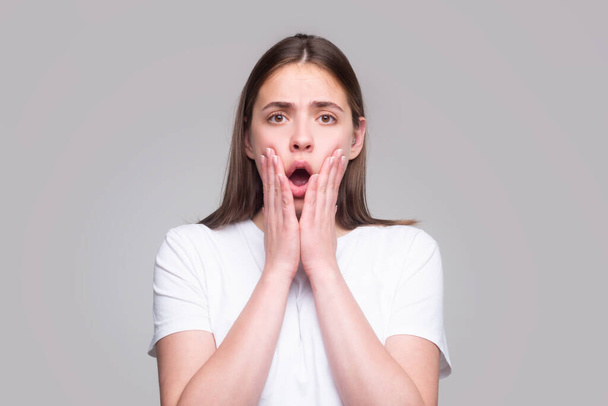 Shocked face of young woman. Funny female shocked face expression. Unbelievable. Portrait of excited woman spreading hands. Expressing surprise open mouth - Foto, Imagen