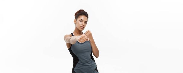Healthy and Fitness concept - portrait of African American woman punching in air with confident face. Isolated on white background - Photo, Image