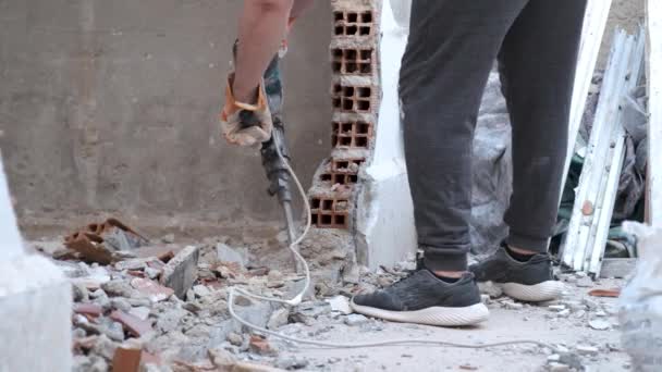 Trabalhador irreconhecível usando um martelo pneumático para perfurar a parede. Local de construção. - Filmagem, Vídeo