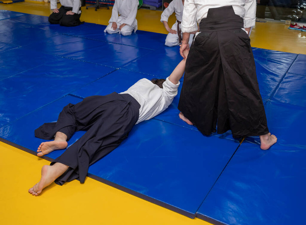 Aikidoka utiliza la técnica de bloqueo conjunto en el oponente durante el entrenamiento de aikido, de cerca - Foto, Imagen