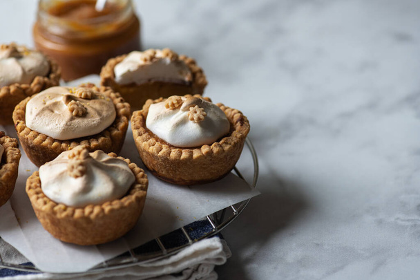 Lemon curd tartlets with whipped meringue on a wire rack. Copy space and close up. - Fotografie, Obrázek