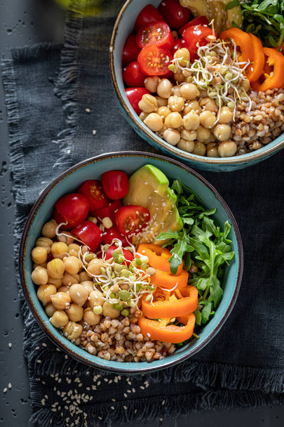 Healthy salad with groats, chickpeas, arugula and vegetables. Nutritious bowl on a diet. - Zdjęcie, obraz