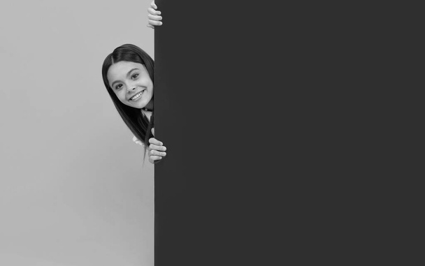 Fotokopi alanı ve reklam için boş pembe kağıt çarşafların arkasında mutlu bir genç kız.. - Fotoğraf, Görsel