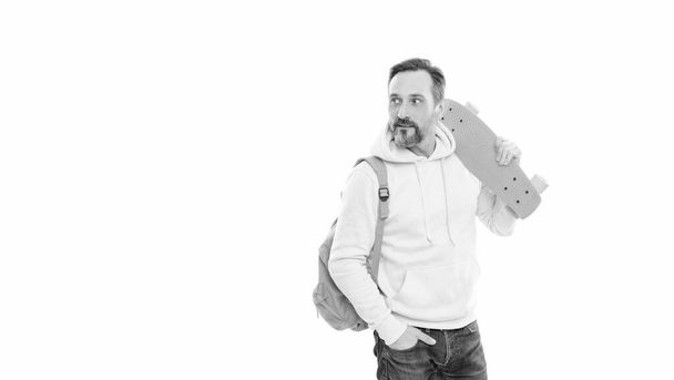 pohledný zralý muž hipster s vousy a knírem v mikině s batohem a penny deska izolované na bílém kopírovacím prostoru, volný čas. - Fotografie, Obrázek